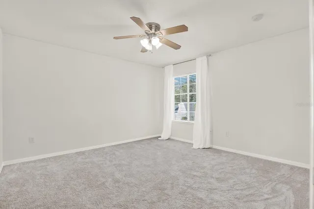 an empty room with closet and ceiling fan