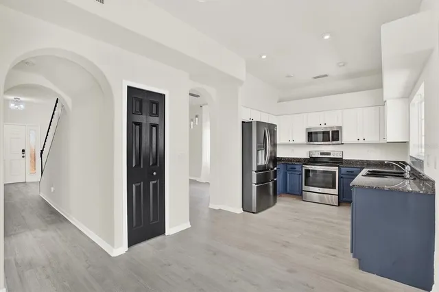 a kitchen with stainless steel appliances granite countertop a refrigerator and a stove top oven