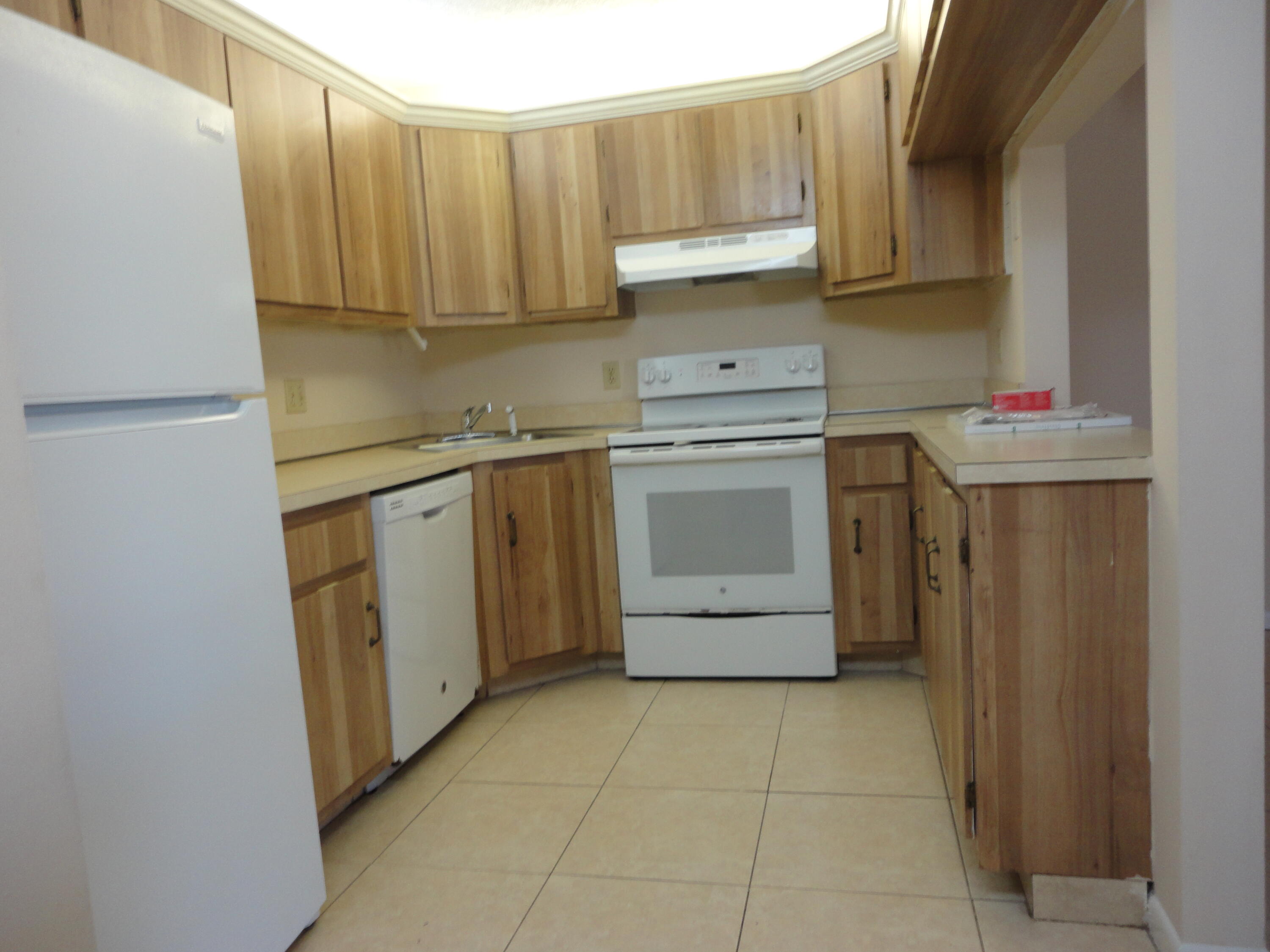4695 Sable Pine Circle, Unit C2 West Palm Beach, FL 33417 - Photo 3 of 14 a kitchen with a stove sink and cabinets