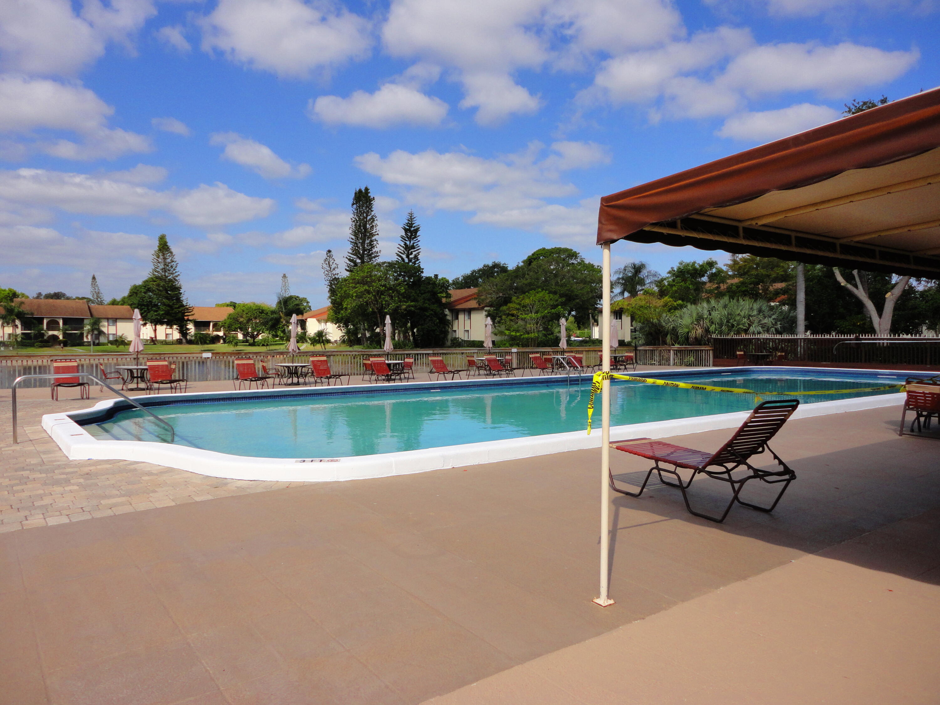 4695 Sable Pine Circle, Unit C2 West Palm Beach, FL 33417 - Photo 10 of 14 a view of lawn chairs and table on the patio