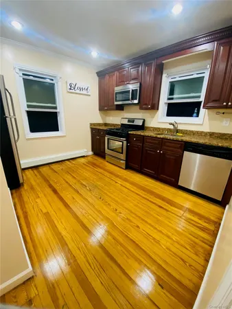 a kitchen with stainless steel appliances kitchen island granite countertop a stove a sink and a microwave