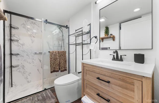 a bathroom with a sink a toilet and shower