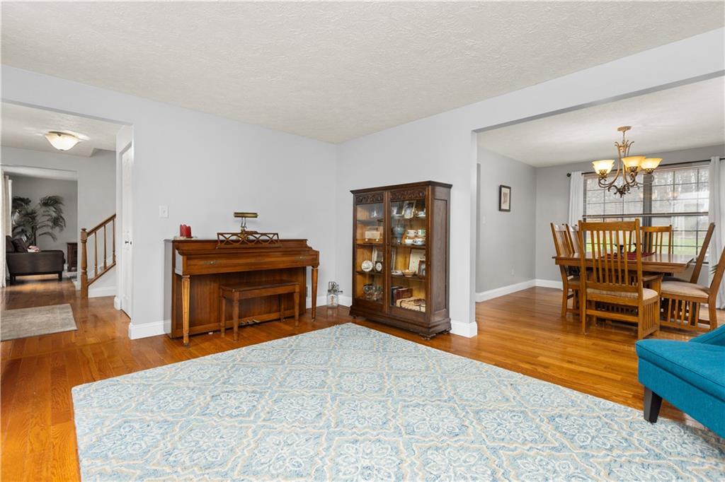203 West Cruikshank Road Butler, PA 16002 - Photo 12 of 32 a living room with furniture and a dining table with bookshelf with wooden floor