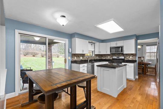 203 West Cruikshank Road Butler, PA 16002 - Photo 6 of 32 a kitchen with a table chairs microwave and cabinets