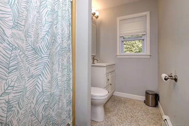 a bathroom with a toilet and a shower curtain