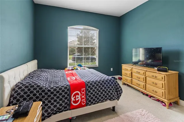 a bedroom with a bed and flat screen tv