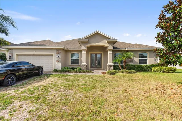 a view of a house with a small yard plants and large tree