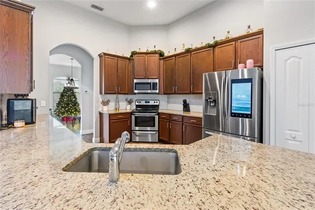 a kitchen with stainless steel appliances granite countertop a sink stove and cabinets