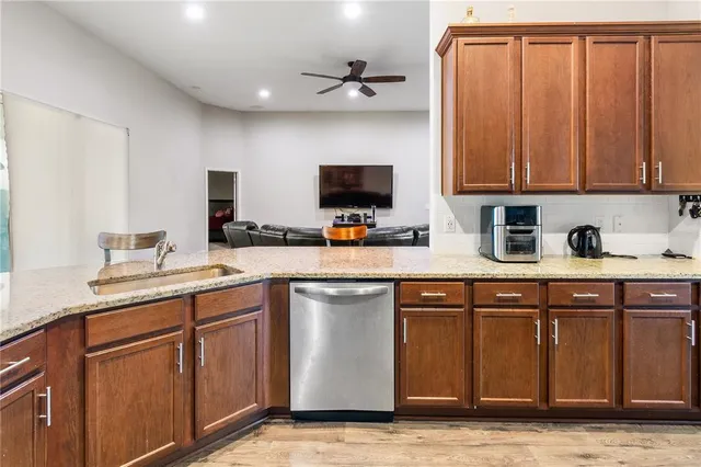 a kitchen with stainless steel appliances granite countertop wooden cabinets a stove top oven a sink and dishwasher