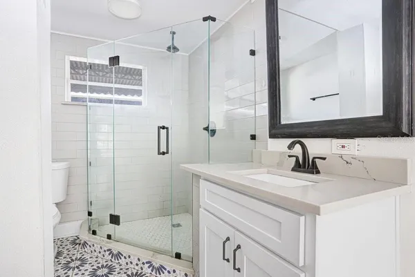 a bathroom with a sink a vanity a mirror and shower