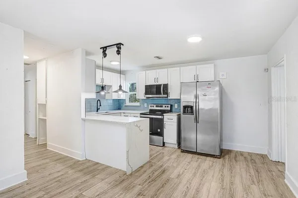 a kitchen with stainless steel appliances a refrigerator sink and cabinets