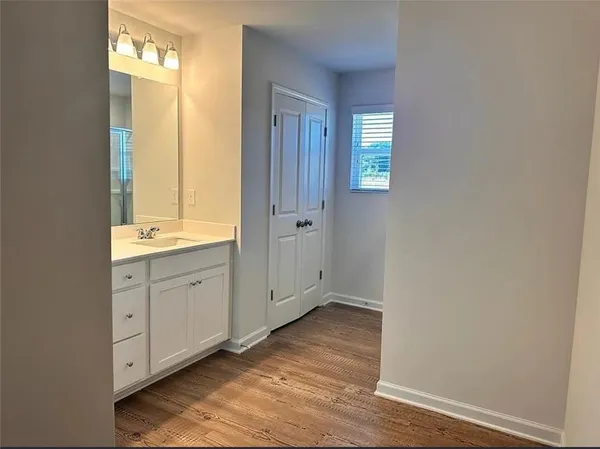 a view of bathroom with a sink mirror and window