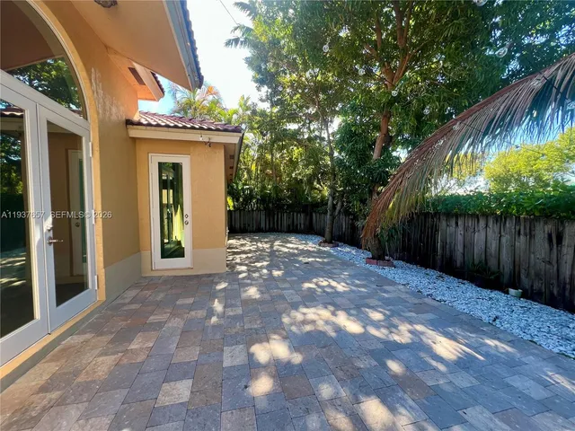 a view of backyard with tree and wooden fence