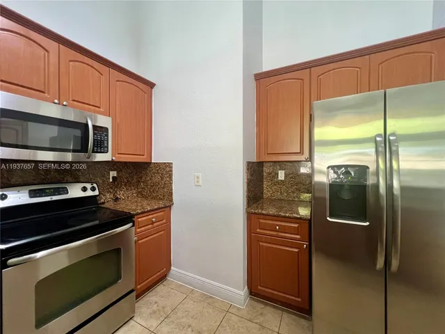 a kitchen with stainless steel appliances a refrigerator and a stove top oven