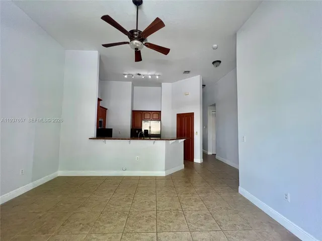 a view of a kitchen with a sink and a refrigerator