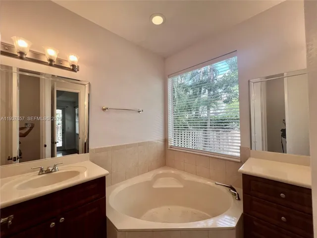 a bathroom with a bathtub sink and mirror