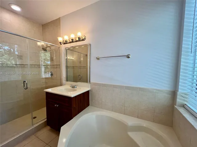 a bathroom with a sink and mirror with shower