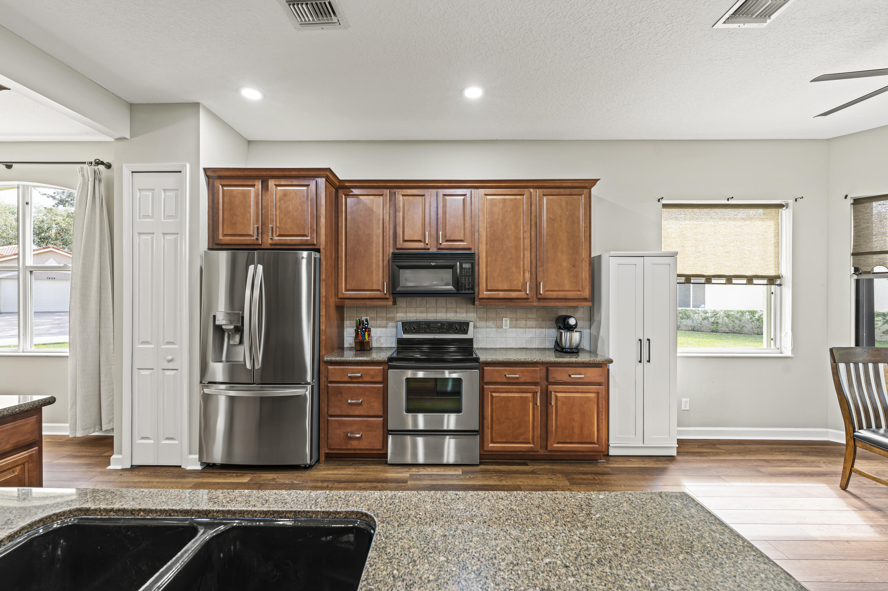 9184 Pumpkin Ridge Port St. Lucie, FL 34986 - Photo 17 of 74 a kitchen with stainless steel appliances granite countertop a refrigerator stove and sink