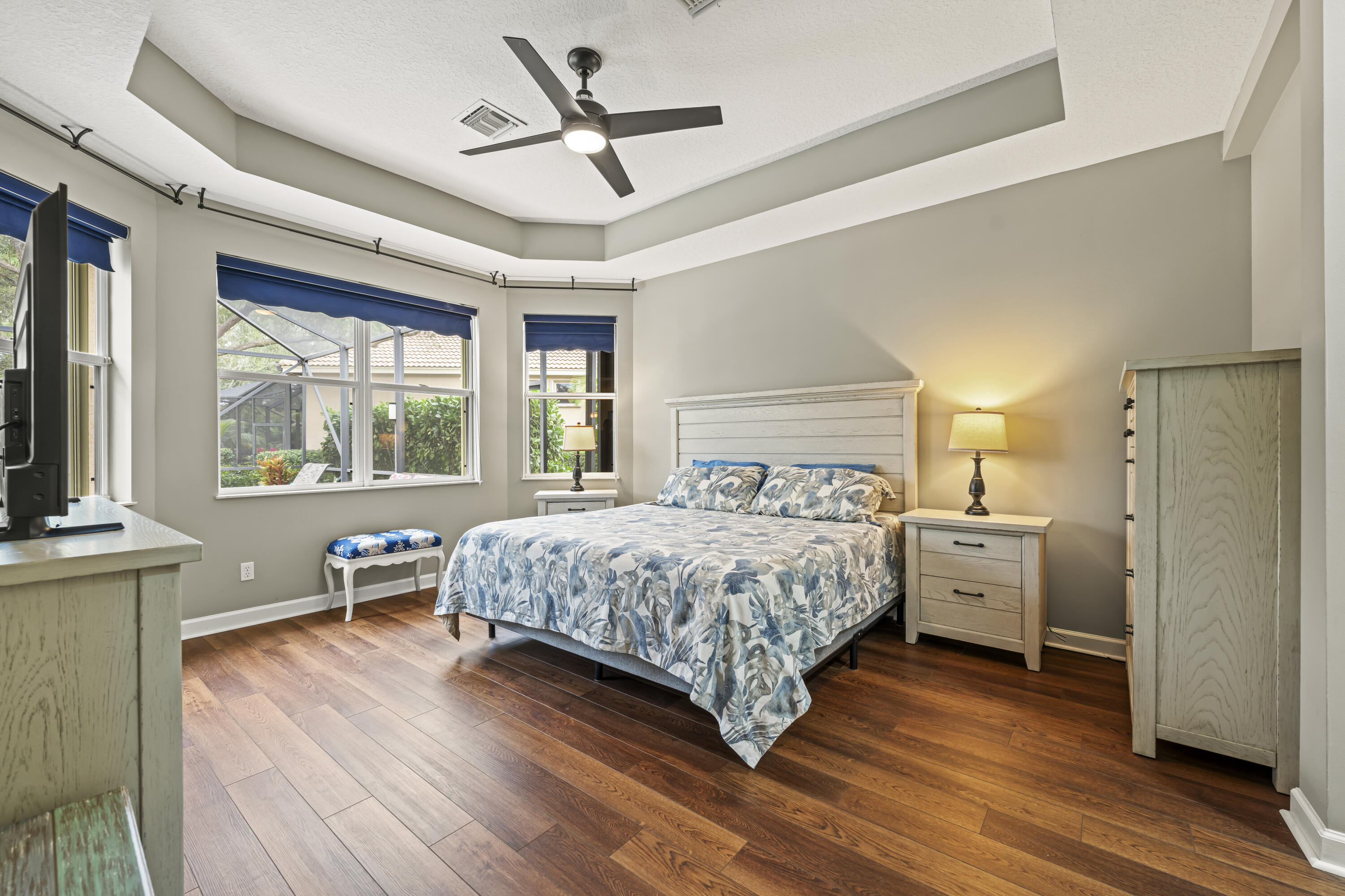 9184 Pumpkin Ridge Port St. Lucie, FL 34986 - Photo 25 of 74 a bedroom with a large bed a large window and wooden floor