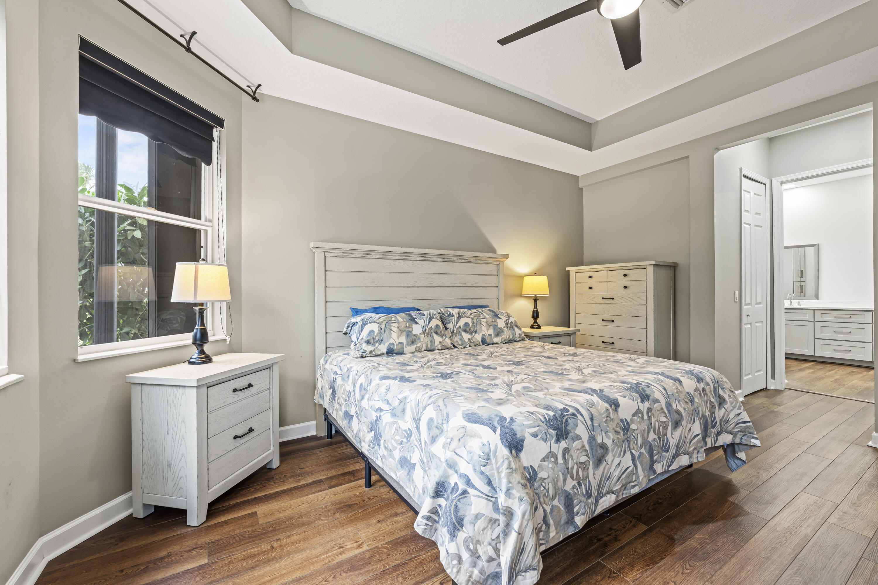 9184 Pumpkin Ridge Port St. Lucie, FL 34986 - Photo 26 of 74 a bedroom with a large bed and a chandelier