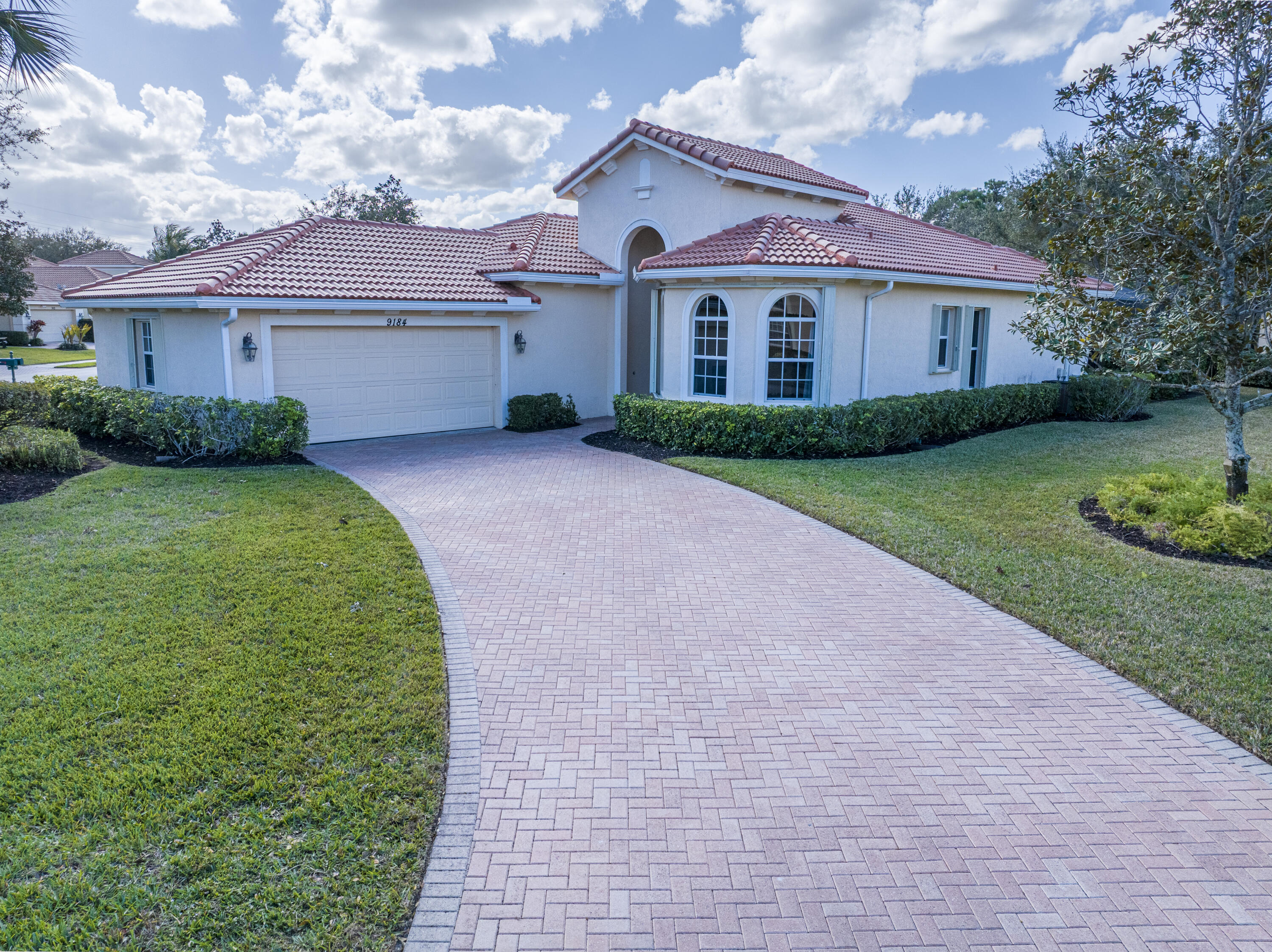 9184 Pumpkin Ridge Port St. Lucie, FL 34986 - Photo 7 of 74 a front view of a house with a garden and yard