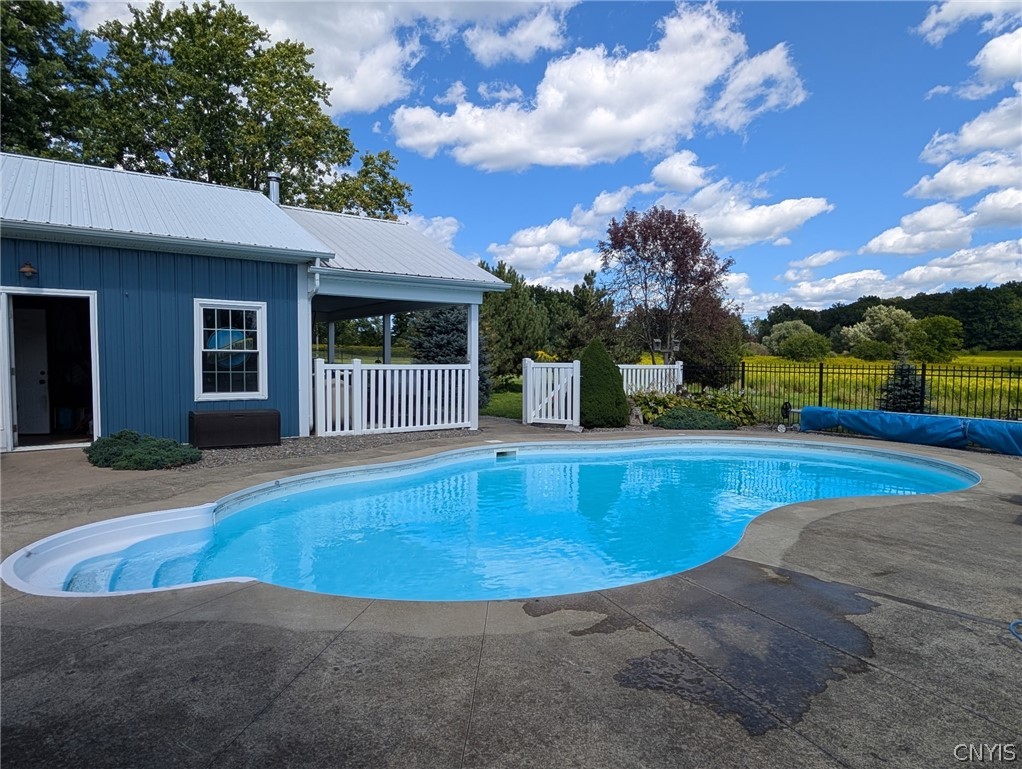 1322 Sawmill Road Sangerfield, NY 13480 - Photo 3 of 50 A sparkling in-ground pool is bordered by a concrete patio next to the pool house.