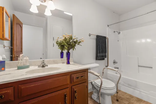 a bathroom with a granite countertop sink a toilet and mirror