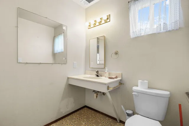a bathroom with a toilet a sink and mirror