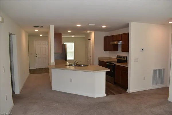 a kitchen with kitchen island stainless steel appliances a sink and a refrigerator