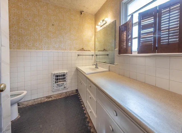 a bathroom with a sink a toilet and a mirror