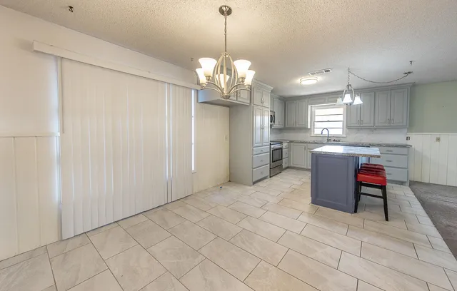 a kitchen with stainless steel appliances granite countertop a sink refrigerator and cabinets