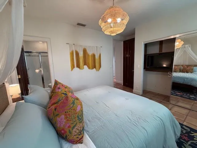 a bedroom with a bed and a chandelier