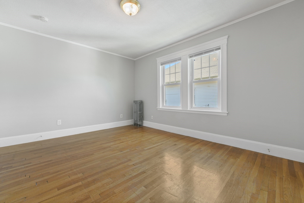 331-333 Vermont Street Boston, MA 02132 - Photo 18 of 26 an empty room with wooden floor and windows