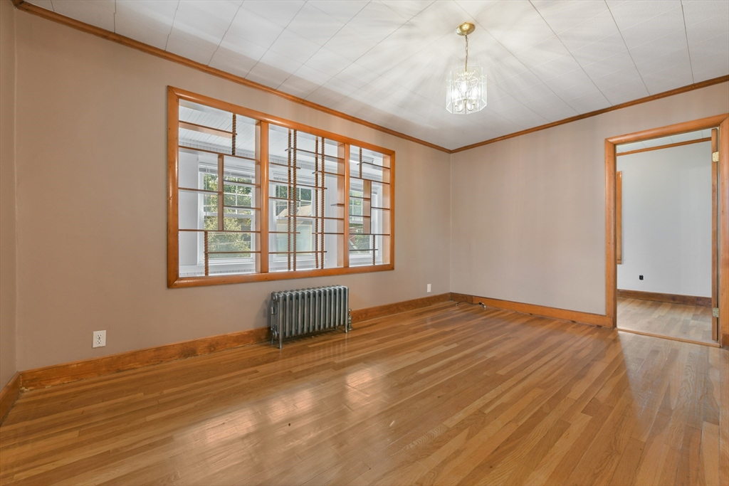 331-333 Vermont Street Boston, MA 02132 - Photo 9 of 26 a view of an empty room with a window and wooden floor