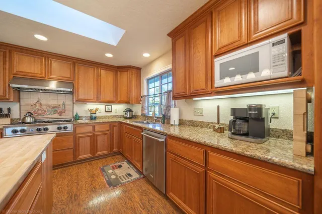 a kitchen with granite countertop stainless steel appliances and sink