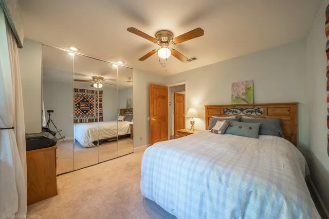 a bedroom with a bed and a ceiling fan
