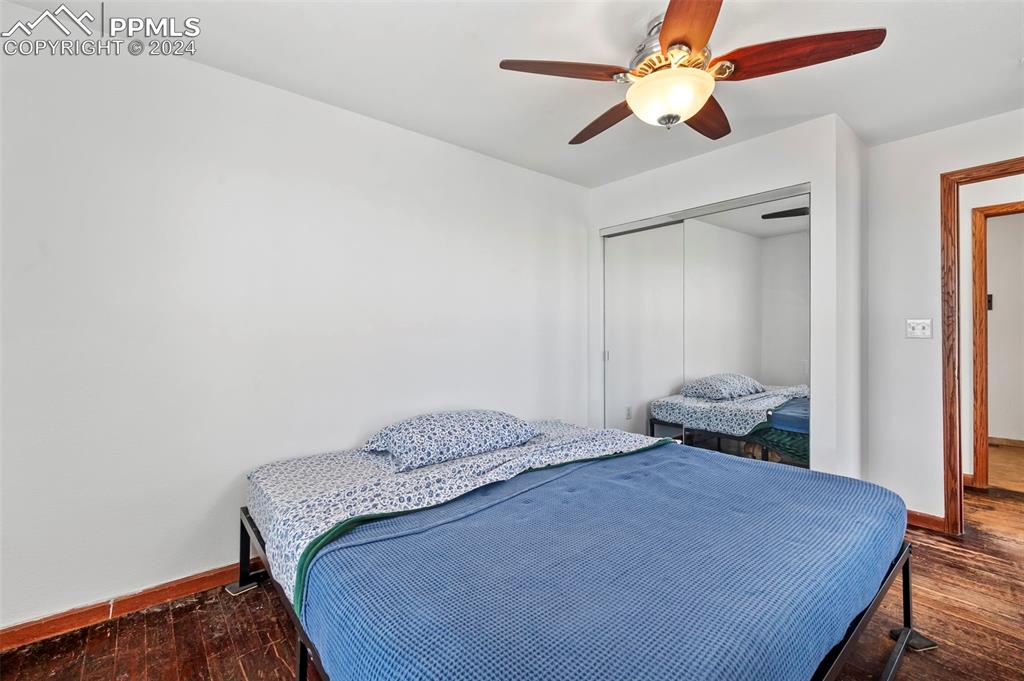 6260 Night Train Lane Yoder, CO 80864 - Photo 20 of 22 Bedroom with ceiling fan, a closet, and wood-type flooring