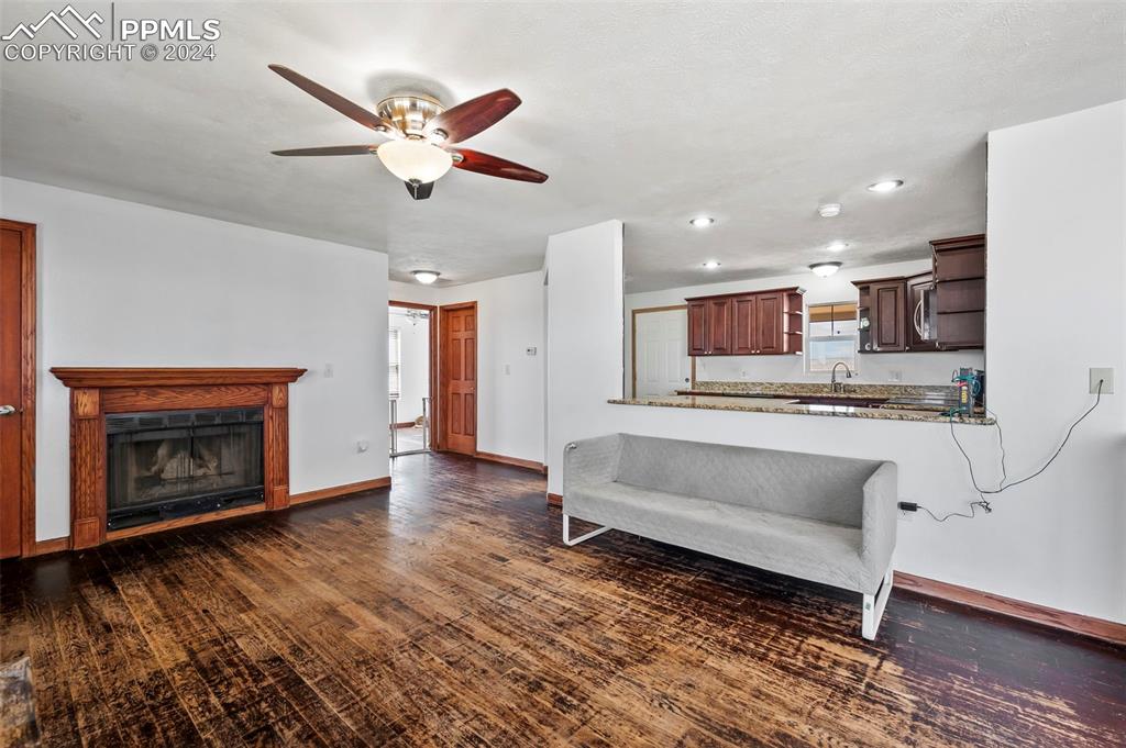 6260 Night Train Lane Yoder, CO 80864 - Photo 10 of 22 Living room featuring sink, ceiling fan, and dark hardwood / wood-style flooring