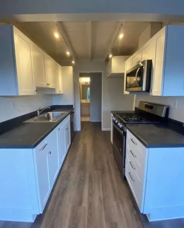 a kitchen with stainless steel appliances a sink stove and cabinets