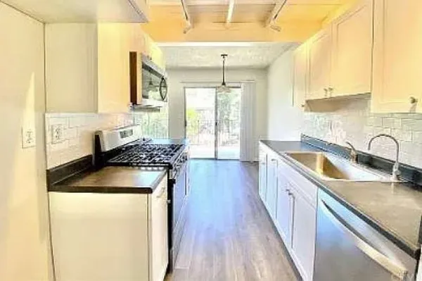 a kitchen with a sink stove and cabinets