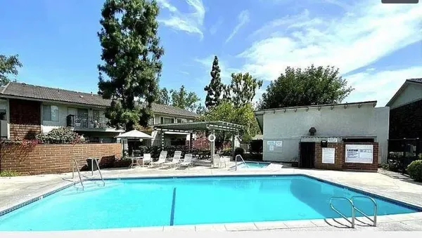 a view of swimming pool with outdoor seating and a garden