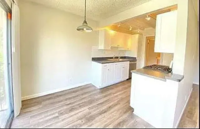a kitchen with granite countertop white cabinets and white appliances