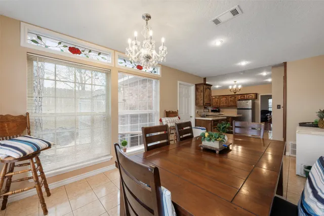 a view of a dining room with furniture a chandelier and wooden floor