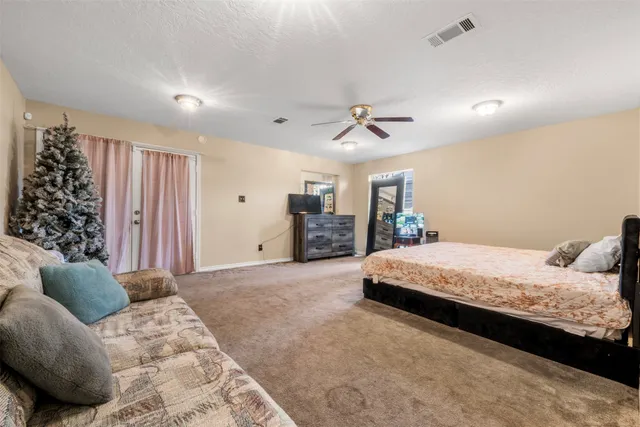 a bedroom with a large bed and a chandelier