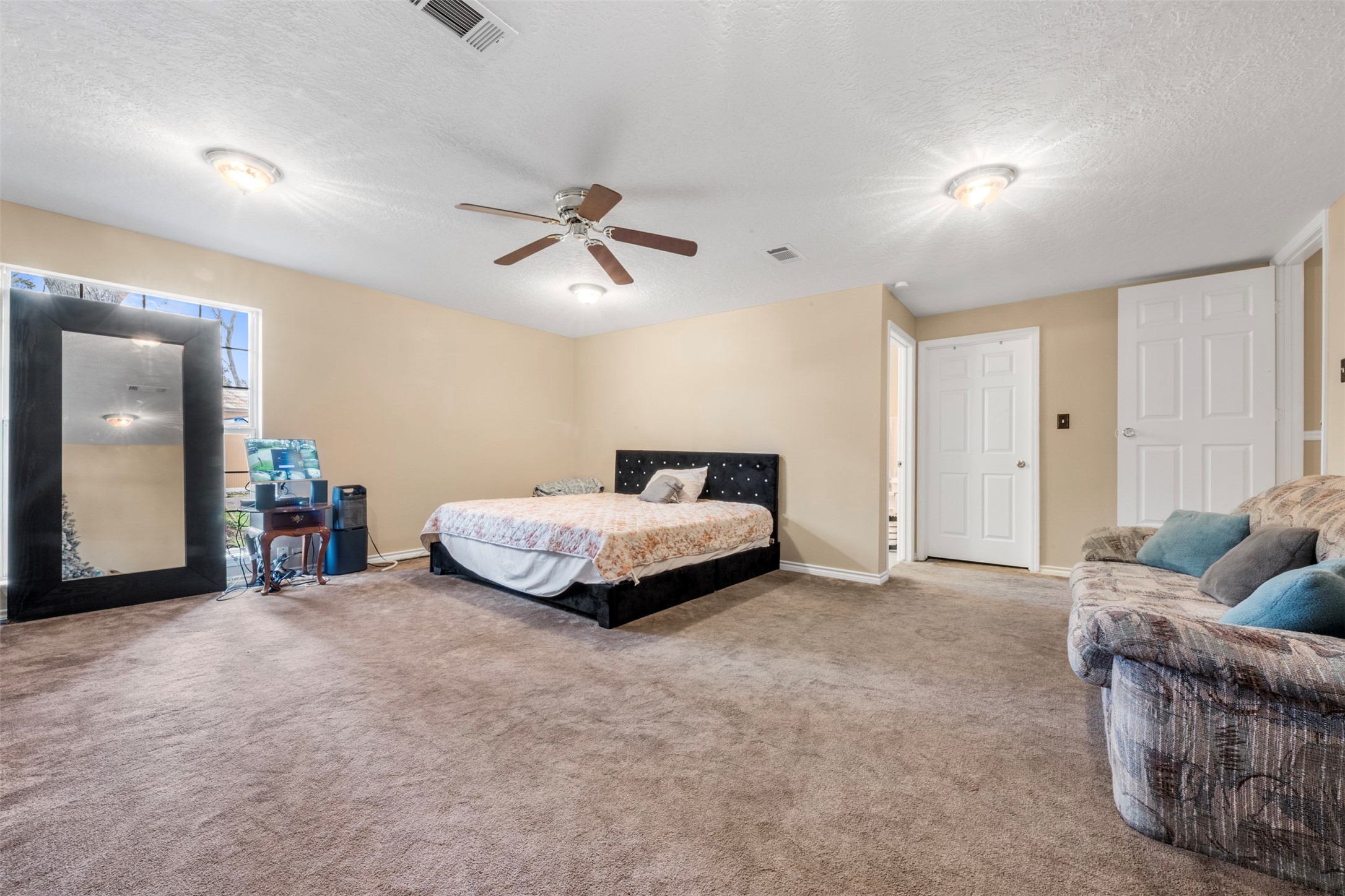 6900 Gregdale Road Houston, TX 77049 - Photo 25 of 49 a spacious bedroom with a bed and a ceiling fan