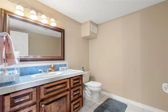 a bathroom with a sink mirror vanity and toilet
