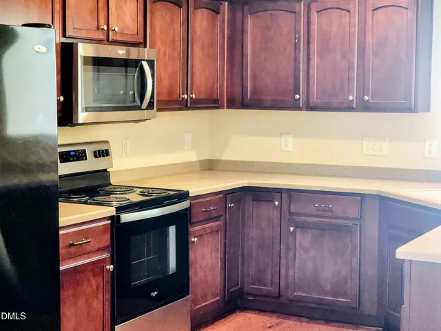 a kitchen with granite countertop wood cabinets and stainless steel appliances