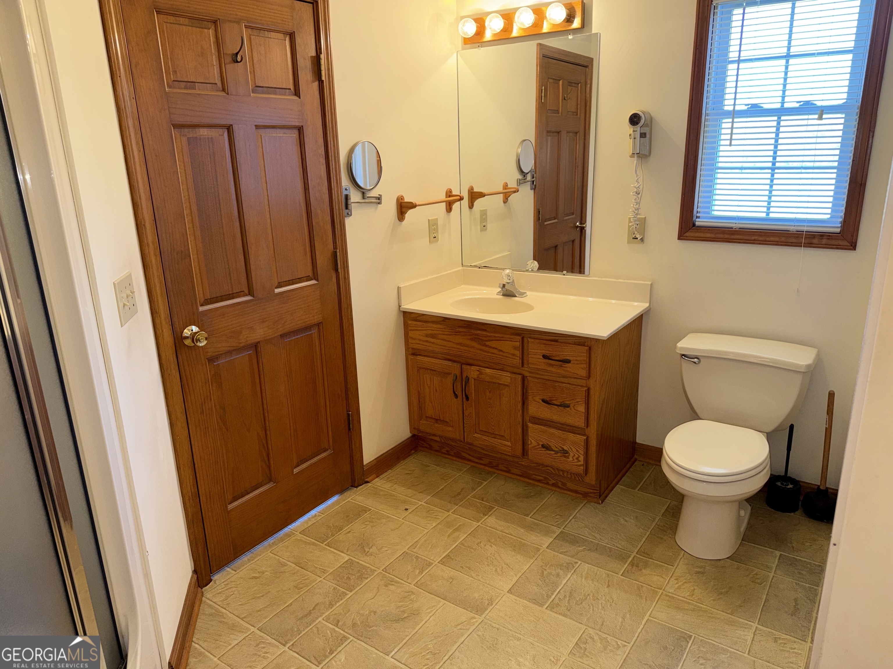 494 Broad Street Bowman, GA 30624 - Photo 34 of 65 a bathroom with a sink a toilet a mirror and vanity