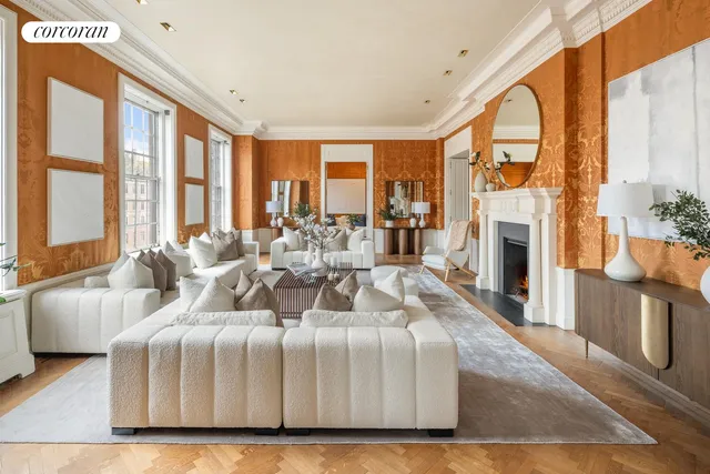 a living room with fireplace furniture large windows and wooden floor