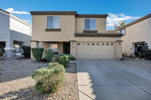 a view of a white house with many windows next to a road